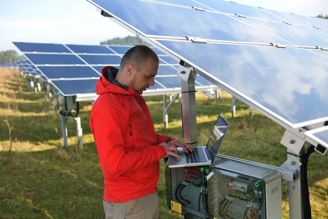 business man  engineer using laptop at solar panels plant eco energy field  in background-1
